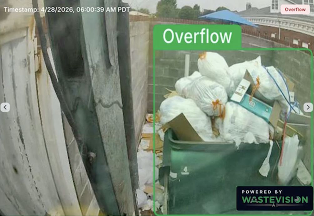 WasteVision AI camera frame flagging an overflowing front-load dumpster